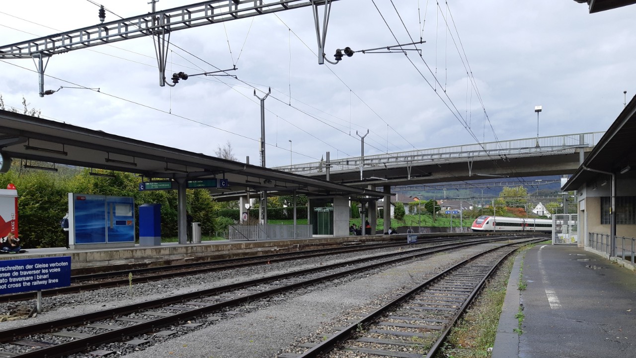Das Foto zeigt den Bahnhof Zwingen in Richtung Osten gesehen, zur Überführung Dorfstrasse hin.