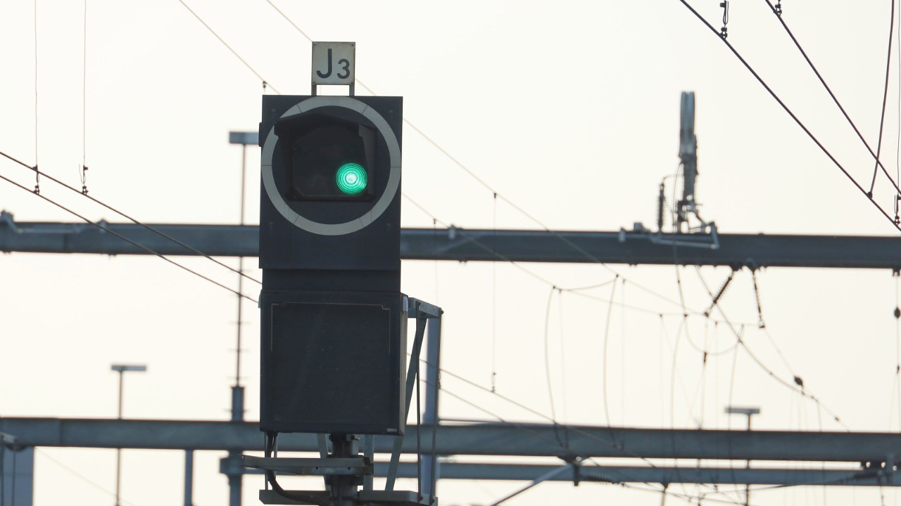Un signal est au vert, indiquant le libre parcours, ce qui permet aux trains de poursuivre leur route.
