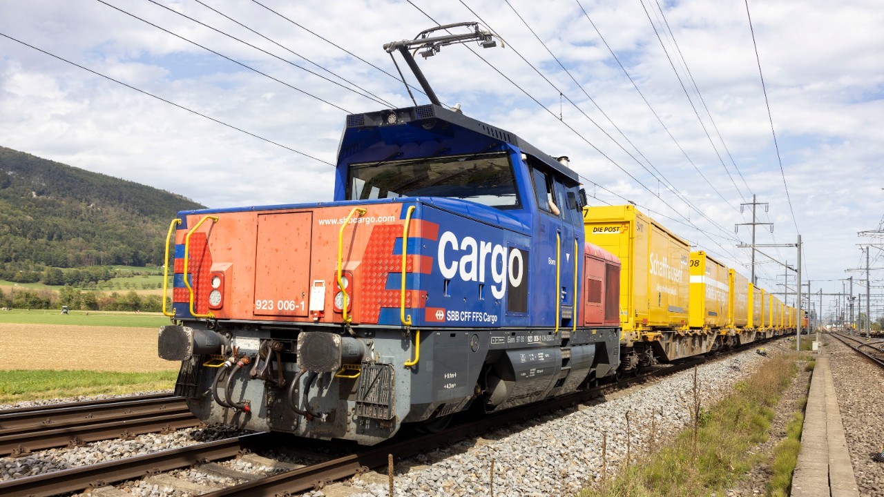 Una locomotiva a doppia alimentazione di FFS Cargo traina i carri della Posta.