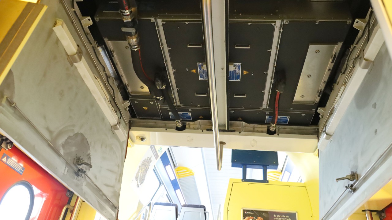 L’image montre la trappe de toit ouverte accédant à la pompe à chaleur, sur l’étage entresol du train.
