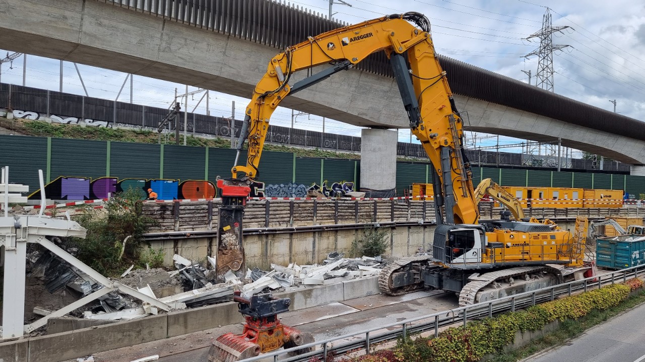 Der 300-Tonnen schwere A-Rex bricht mit seiner roten Abbruchzange die Installationsplattform der Donnerbaumbrücke ab.