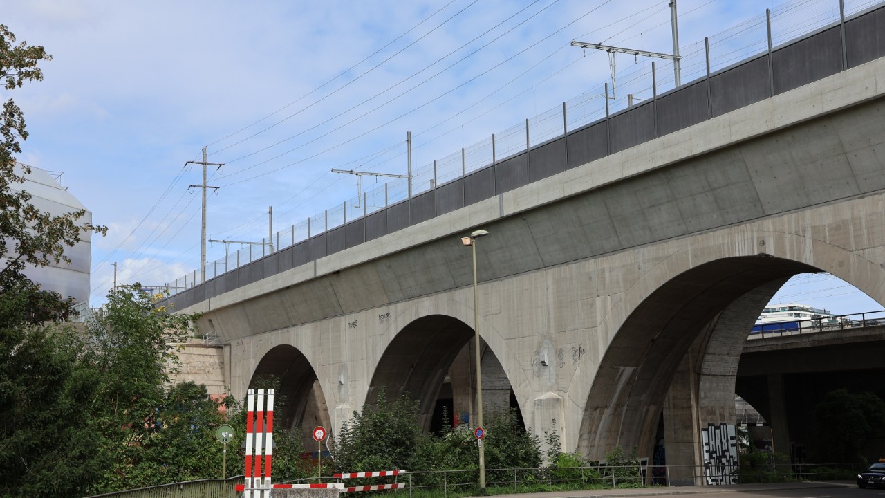 Das Bild zeigt eine Seitenansicht der neu versträkten Birsbrücke, auch die neue Lärmschutzwand auf der Brücke ist gut erkennbar.