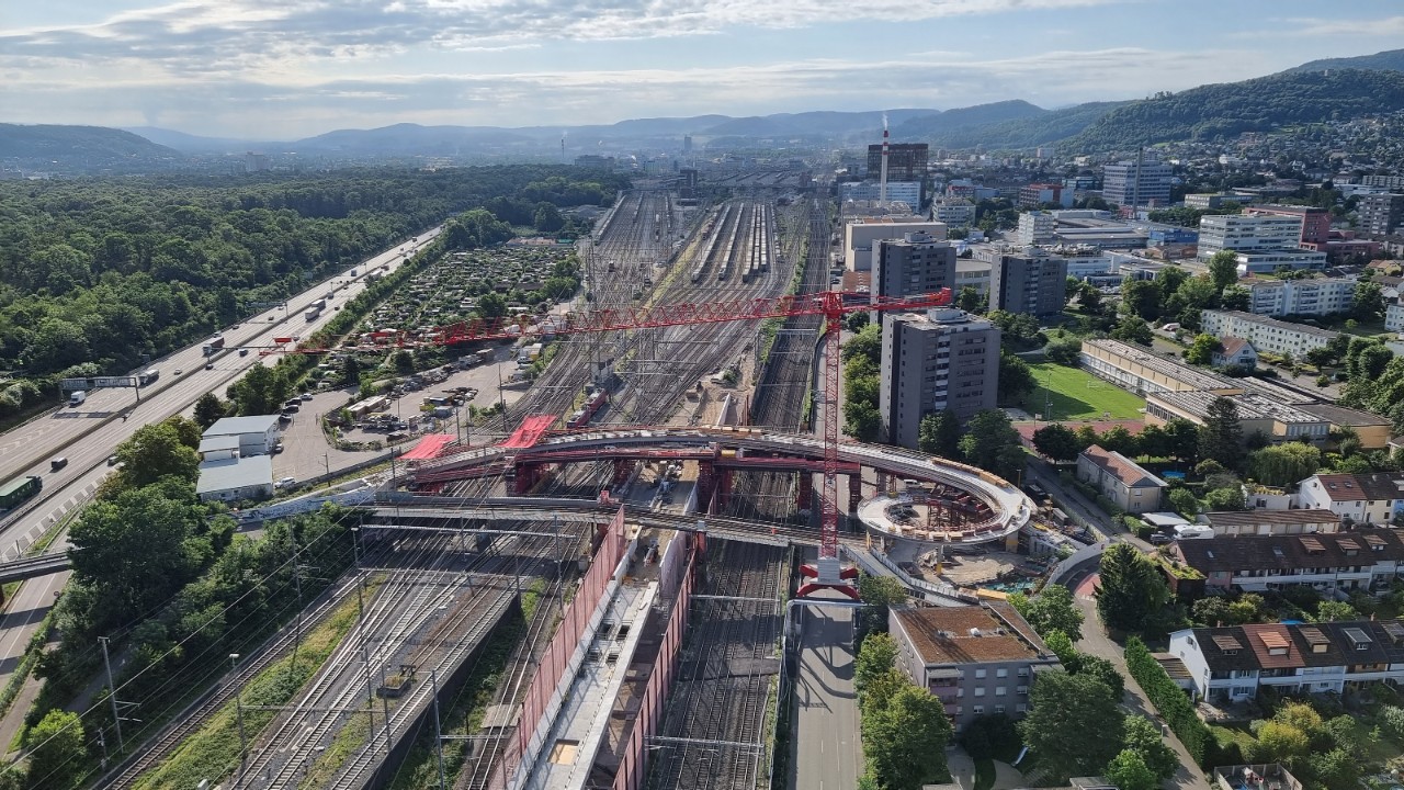 Das Bild zeigt die neue Passerelle Hagnau in einer Luftansicht von Kran 3. Das Brückenbauwerk ist nun durchgehend und spannt sich über das gesamte Gleisfeld.