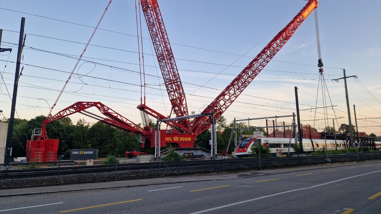 Das Foto vom 18. Juni 2024 zeigt den eindrücklichen Raupenkran «LR 1100». Der Kran hat in der Nacht von 17. auf den 18. Juni das Stahlwerk der neuen oberen Brücke auf die Verschubbahn gehoben. Nun ist er bereit, in der Nacht von 18. auf den 19. Juni das Stahlwerk der bestehenden oberen Bücke auszuheben. Der Kran kann Lasten bis 1000 Tonnen heben. 