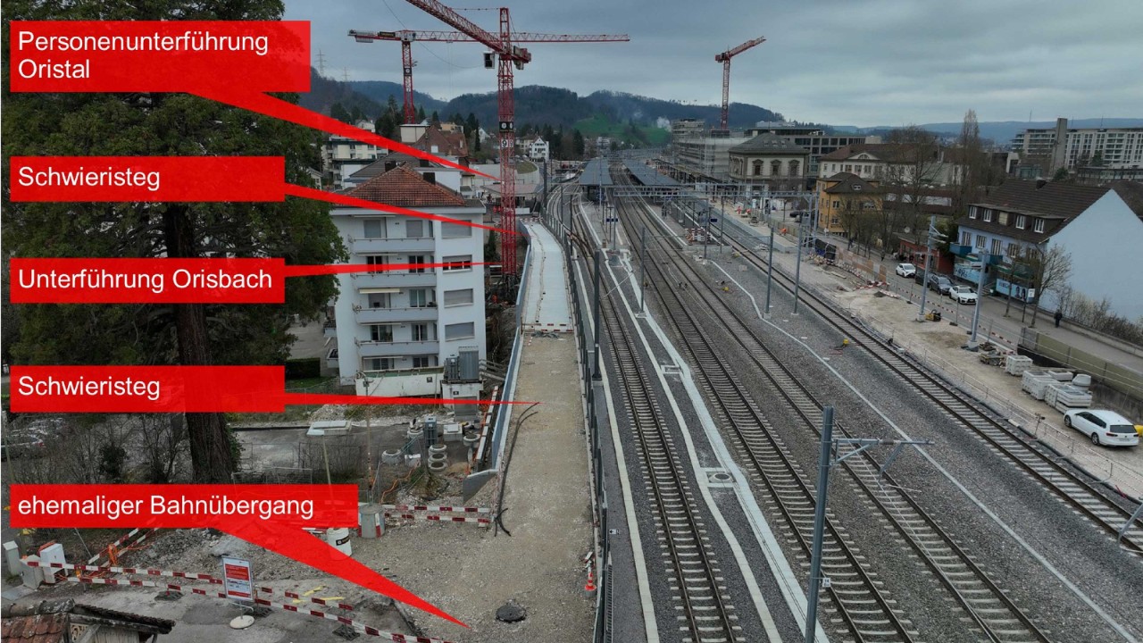 Das Foto vom 4. März 2024 zeigt den Stand der Arbeiten für den Schwieristeg vom Schwieriquartier in Richtung Bahnhof gesehen. Der Steg führt entlang der Gleise, überquert den Orisbach und endet beim südlichen Zugang der Unterführung Oristal.