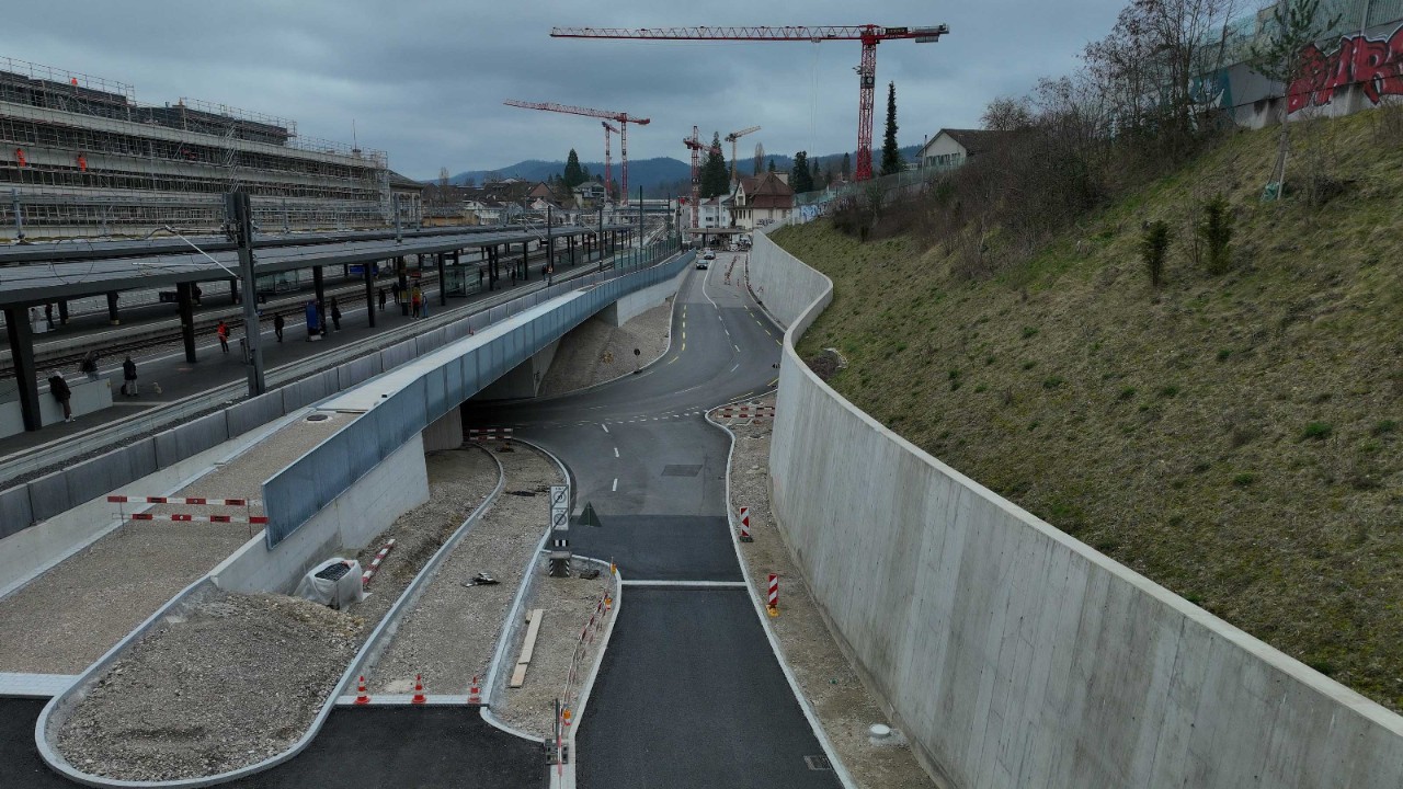 Das Foto von Anfang März 2024 zeigt die neue Stützmauer Sichternstrasse in Richtung Oristalstrasse gesehen. Über der Unterführungszufahrt verläuft der neue Sichternsteg für den Velo- und Fussverkehr. Unter ihm ist die Zufahrt zum neuen, erhöhten Veloweg in der Strassenunterführung erkennbar.