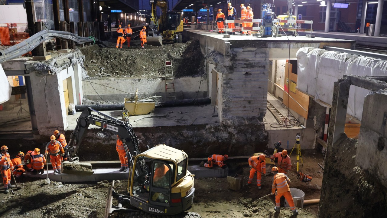Das Bild zeigt Nachtarbeiten am Bahnhof Muttenz während des Bauwochenendes. Anstelle von Gleis 1 und 2 klafft eine grosse Baugrube.