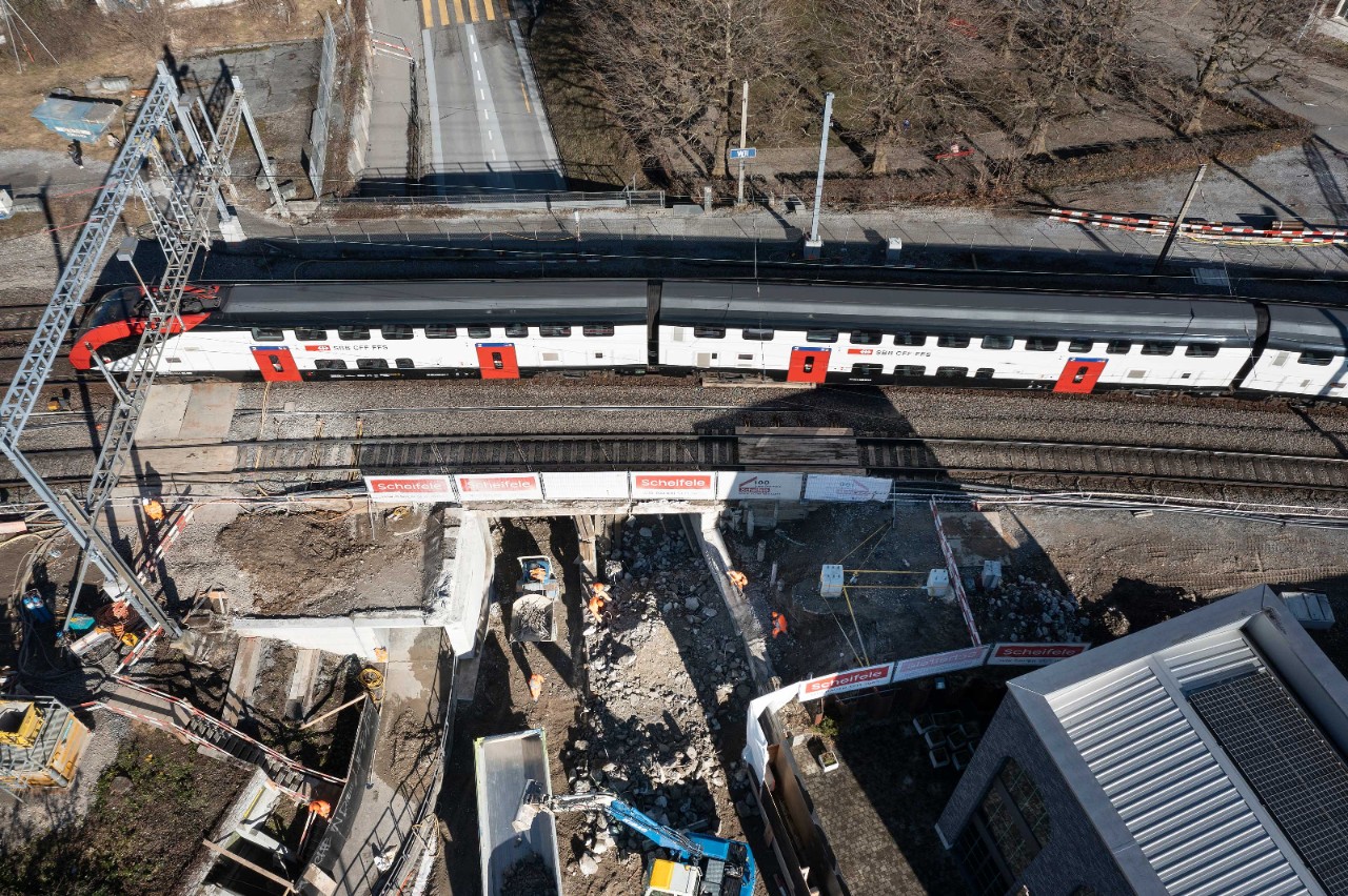 Februar 2022: Während des Betonabbruchs des Brückensegments bei der Unterführung Hubstasse fahren oberhalb die Züge durch.