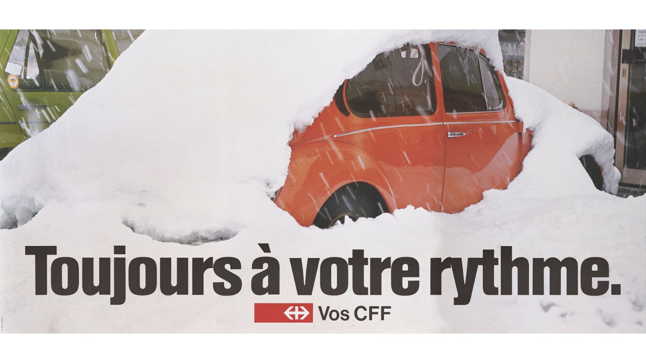 Affiche publicitaire des CFF sur l’introduction de l’horaire cadencé avec une voiture rouge recouverte de neige. Sur l’affiche, les mots «Weiter im Takt».