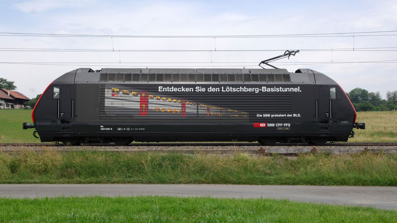 Side view of the SBB Re 460 locomotive advertising the newly-opened Lötschberg Base Tunnel.