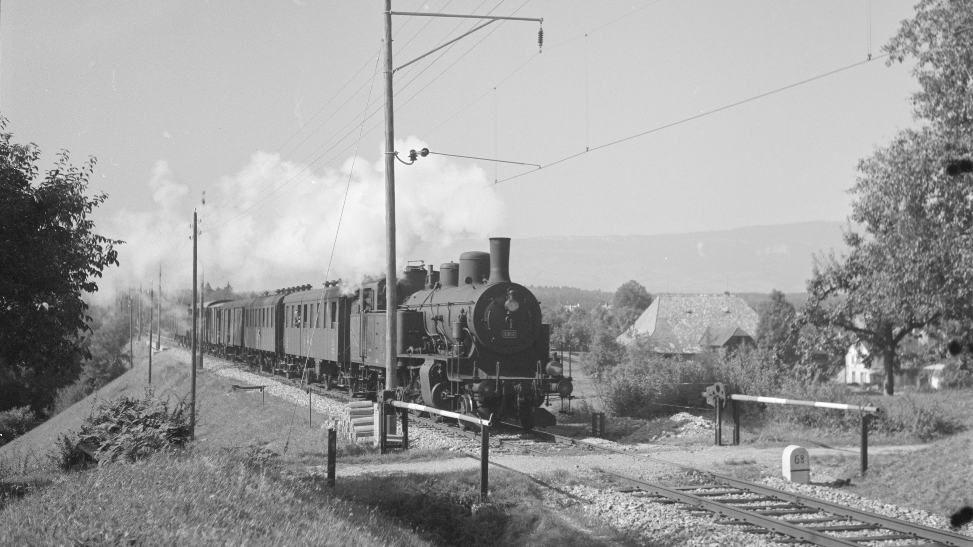 Black and white photograph of a steam train travelling along a railway line, 1944.