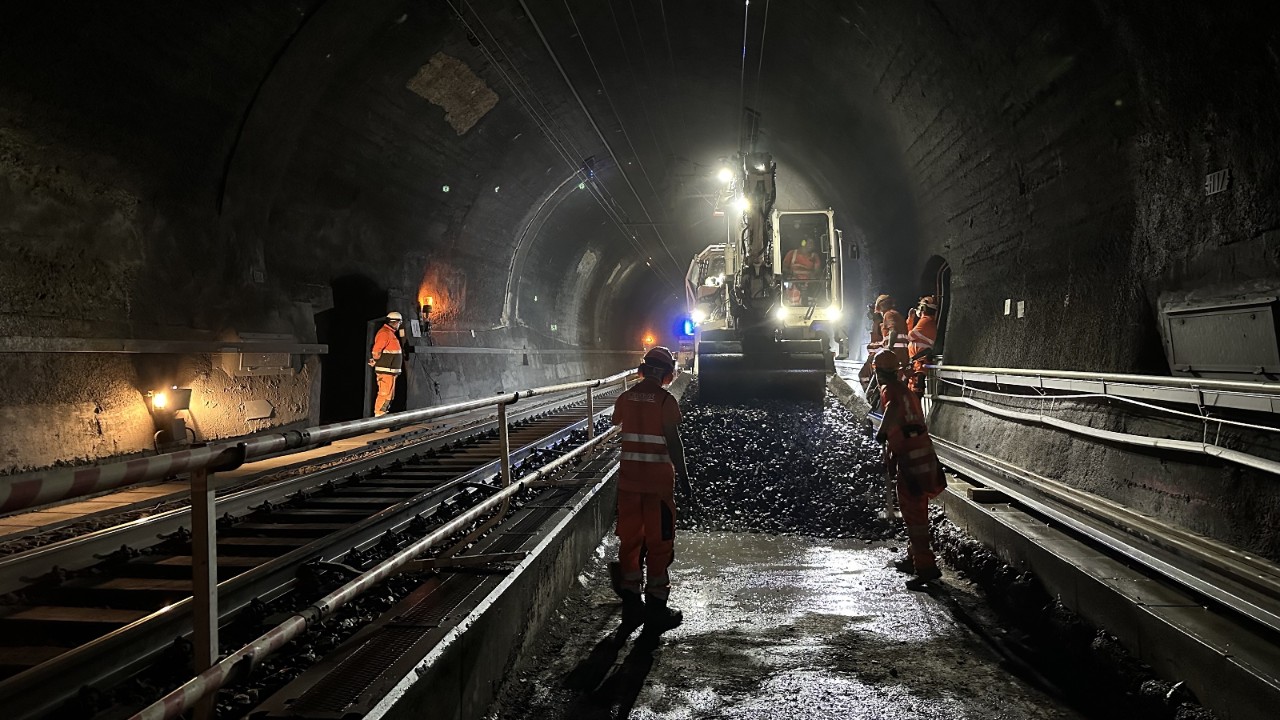 Das Foto vom 12. Juli 2024 zeigt die Arbeiten für die damaligen Gleiserneuerungsarbeiten im Hauenstein-Basistunnel. Der alte Schotter wird mit einem Gleisbauzug ausgebaut. 