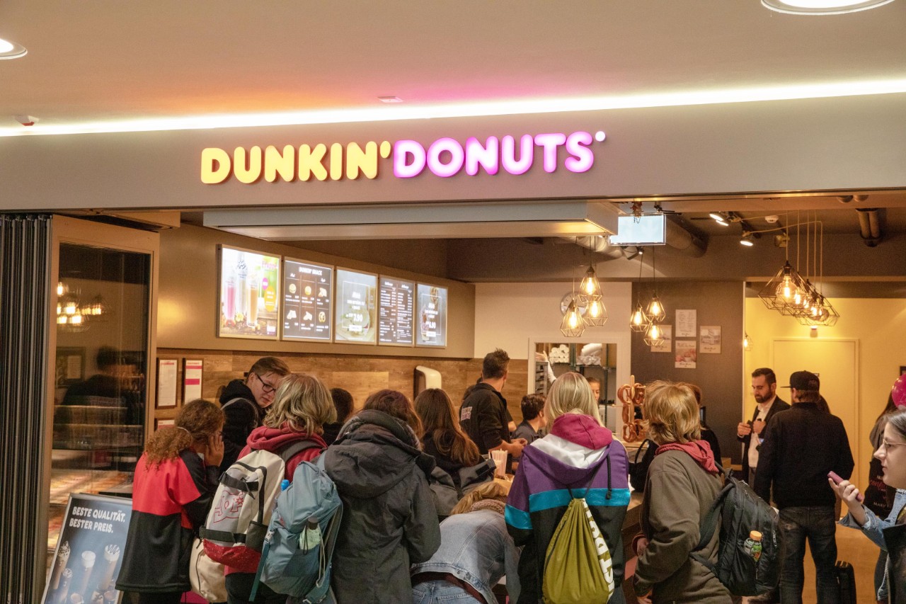 Eine Gruppe Schüler drängt sich vor den Auslagen der Dunkin’ Donuts-Filiale.
