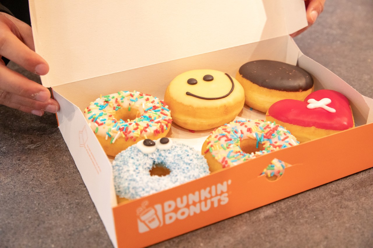Blick in einen Sechserpack-Karton mit bunten Donuts.