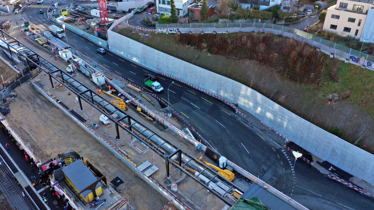 Das Foto vom Dezember 2021 zeigt von der Seite Bahnhofgebäude her Richtung Oristalstrasse gesehen den Bau des Gemeinschaftsperrons von SBB und Waldenburgerbahn über der Verlängerung der Strassenunterführung Oristal sowie die ihr gegenüberliegende Stützmauer Sichternstrasse