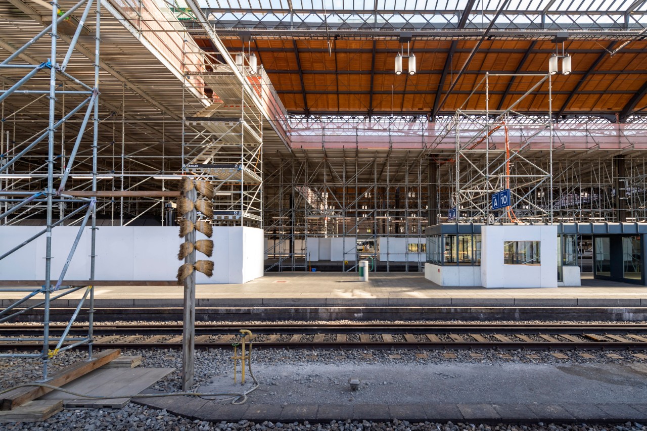 Das Foto zeigt das Gerüst der Arbeitsbühne während der Sanierungsetappe 2 vom Perron Gleis 11 aus in Richtung Norden, beziehungsweise Centralbahnstrasse, gesehen. Das Gerüst befindet sich zu diesem Zeitpunkt in der Mitte der Perronhallen.