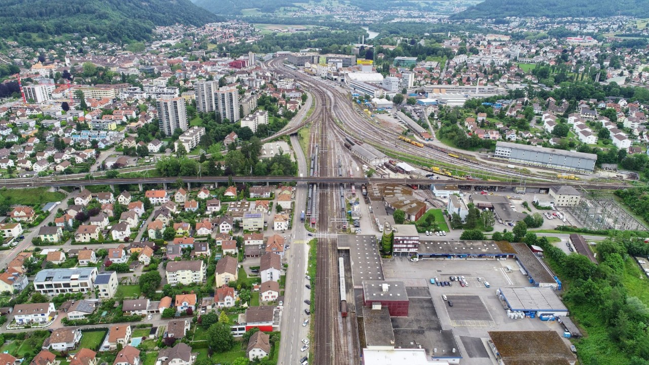 Das Foto zeigt den Viadukt von Westen (Seite Aarau) Richtung Osten (Seite Bahnhof Brugg) gesehen. Er überspannt unter anderem die Aarauerstrasse (links der Gleise), die Bahnlinie Brugg–Aarau und das Areal der Stiftung Bahnpark Region Brugg (rechts der Gleise).